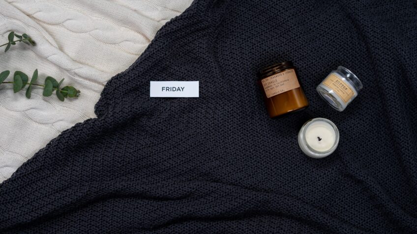 Warm knitted blanket with candles and eucalyptus for a cozy fall ambiance