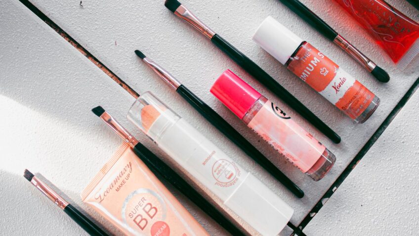Flatlay of makeup products and brushes for a fall beauty routine